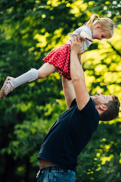 Отец держит свою дочь в воздухе