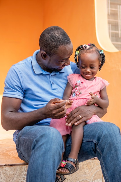 Foto gratuita padre che tiene la sua bambina nera