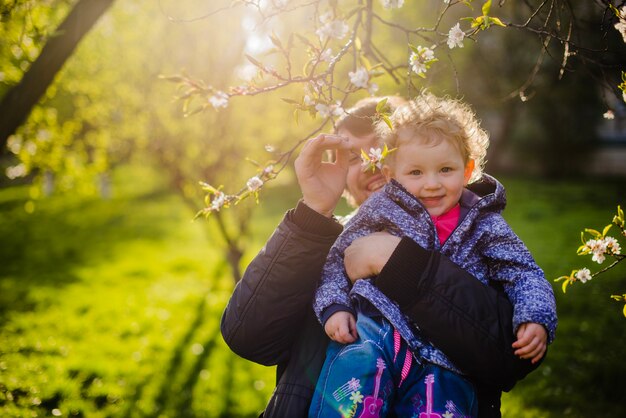 Father holding his son and grabbing a branch