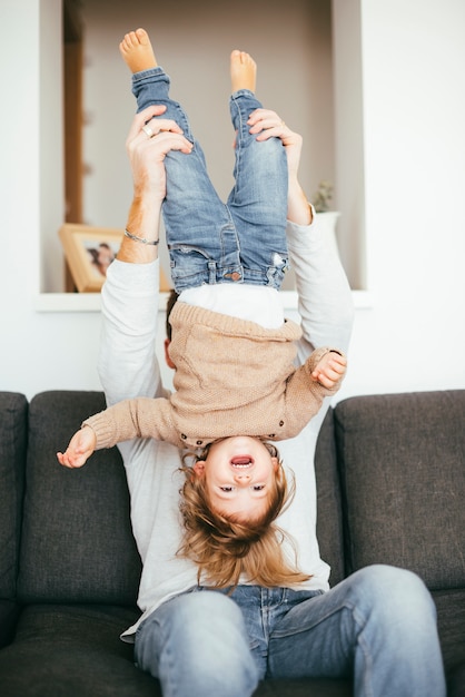 Free photo father holding kid upside down