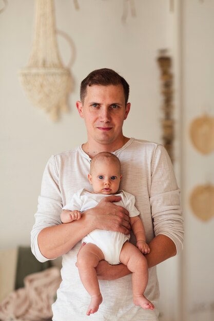 Father holding newborn baby medium shot