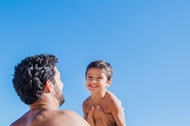 Father holding son at the beach