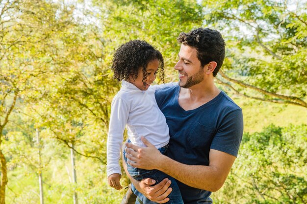 Father holds daughter on arms