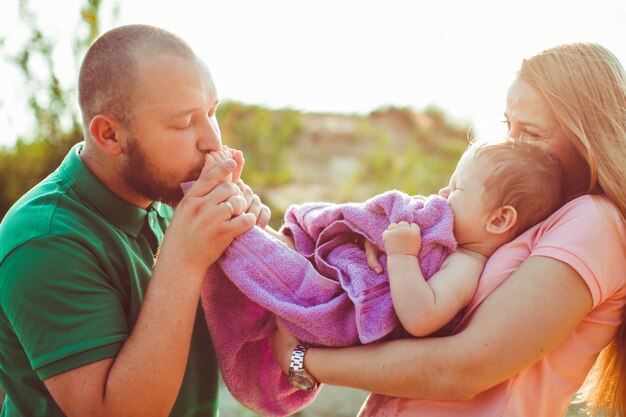 父は紫のタオルで包まれた彼の子供の足を保持する