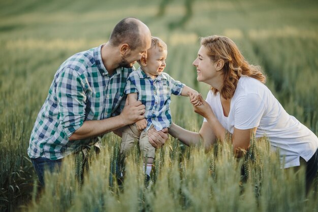 Father holds a son and a mother keeps him for hands