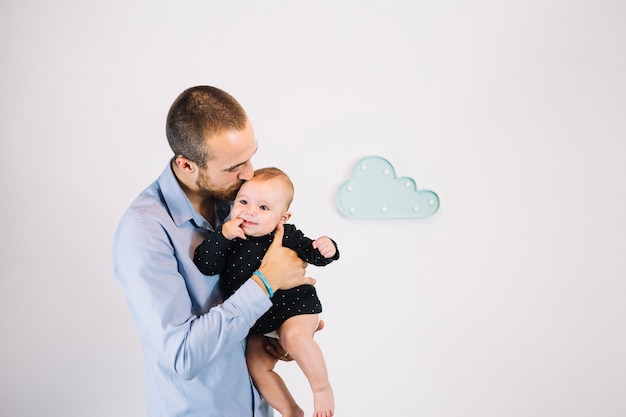 father kissing cute baby