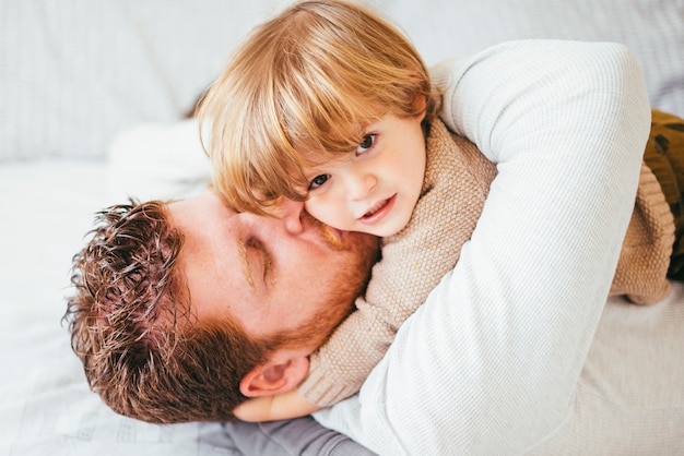 父親が子供にキスをして抱き締める