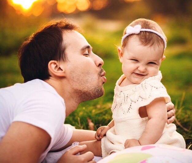 Father lies before little girl on the lawn 