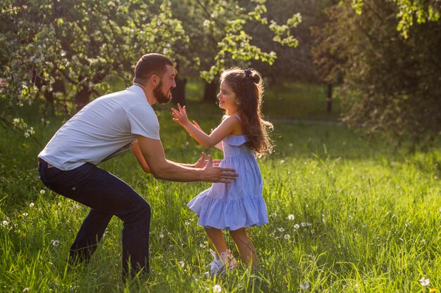 Father lifting his daughter in park