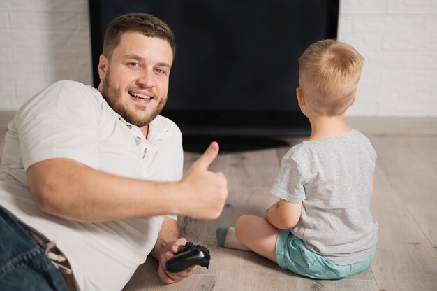 Father looking at camera while staying next to his son