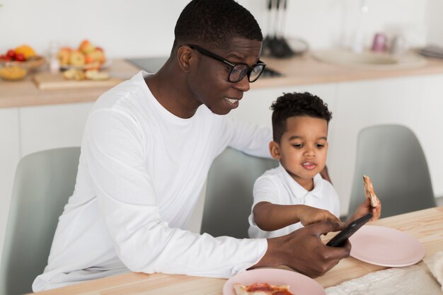 Father looking at something on his phone with his son