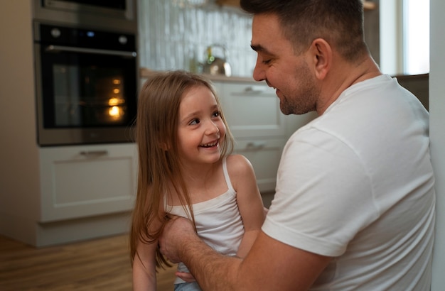 Бесплатное фото Отец заставляет свою дочь смеяться, щекоча ее