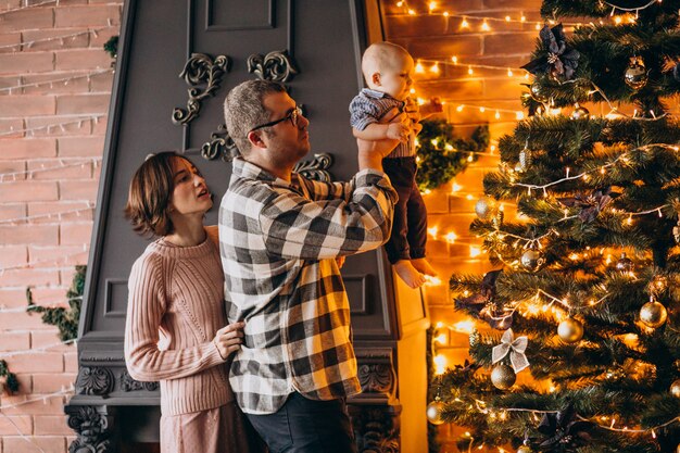 Father mother and little son decorating Christmas tree