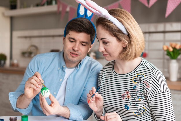 Father and mother painting eggs for easter