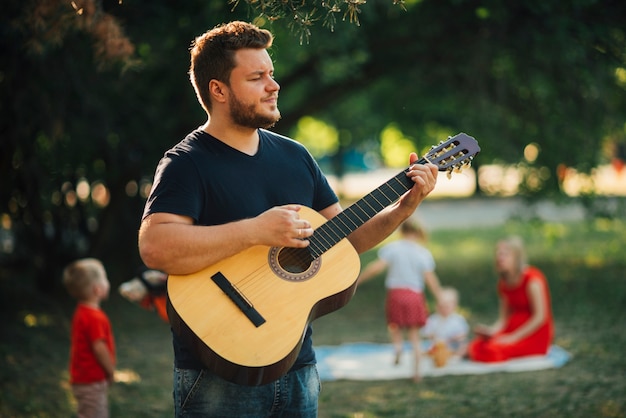 Foto gratuita padre giocando sulla chitarra classica