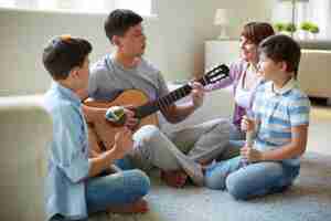 Free photo father playing guitar at home