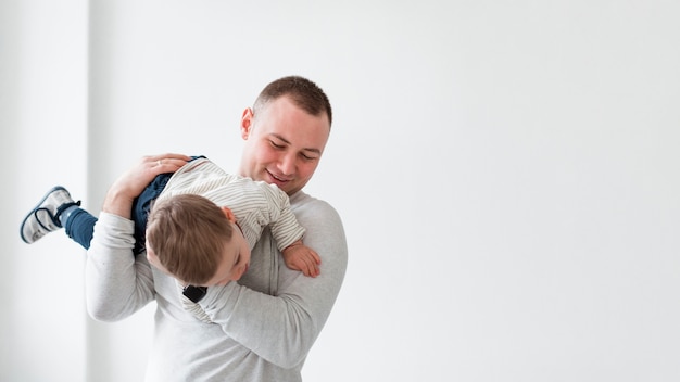 Father playing with child and copy space