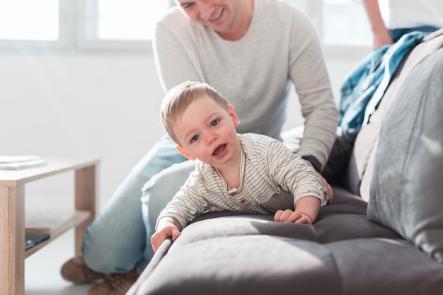 Padre che gioca con il bambino sul divano