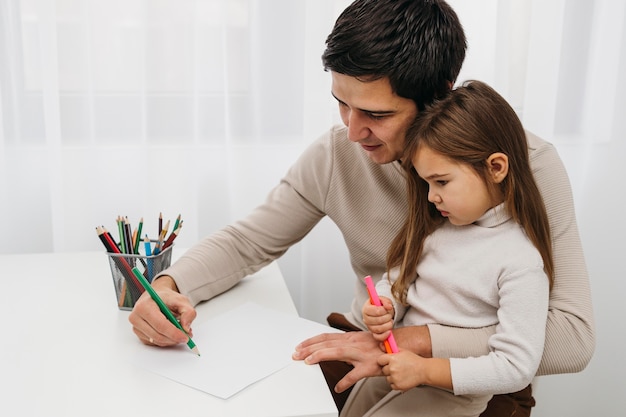 Father playing with crayons with daughter