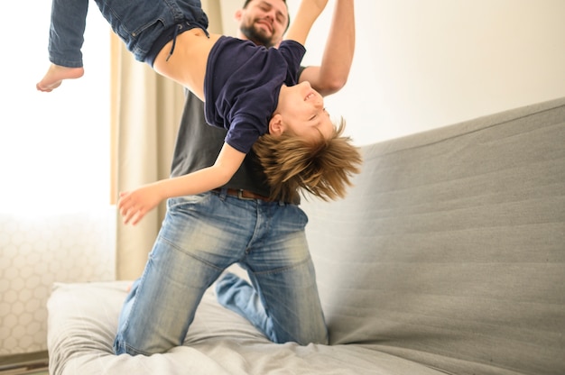 Free photo father playing with son on sofa