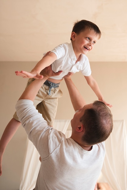 Free photo father playing with toddler indoors