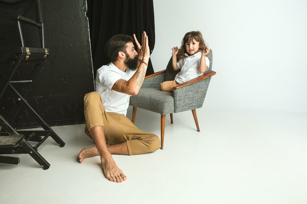 Father playing with young son in their sitting room at home. Young dad having fun with his children in holidays or weekend. Concept of parenthood, childhood, father's day and family relationship.