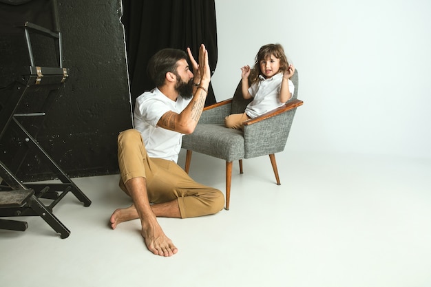 Father playing with young son in their sitting room at home. Young dad having fun with his children in holidays or weekend. Concept of parenthood, childhood, father's day and family relationship.