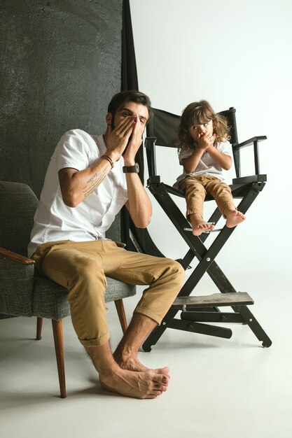 Father playing with young son in their sitting room at home. Young dad having fun with his children in holidays or weekend. Concept of parenthood, childhood, father's day and family relationship.