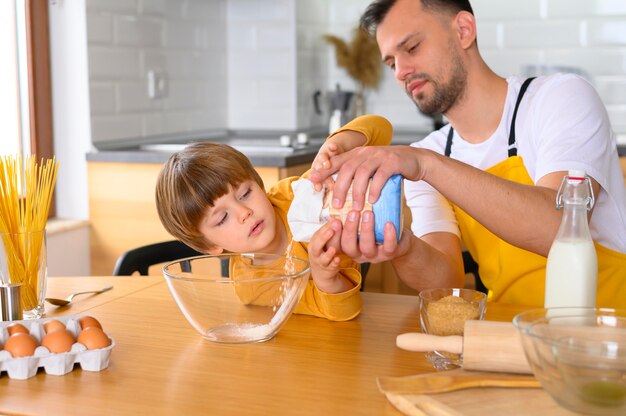 Father pours flour in the bowl