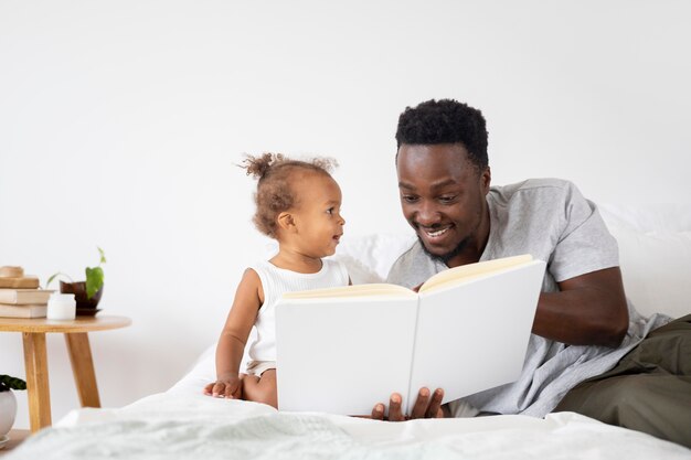 그녀의 아기 소녀에게 읽어주는 아버지