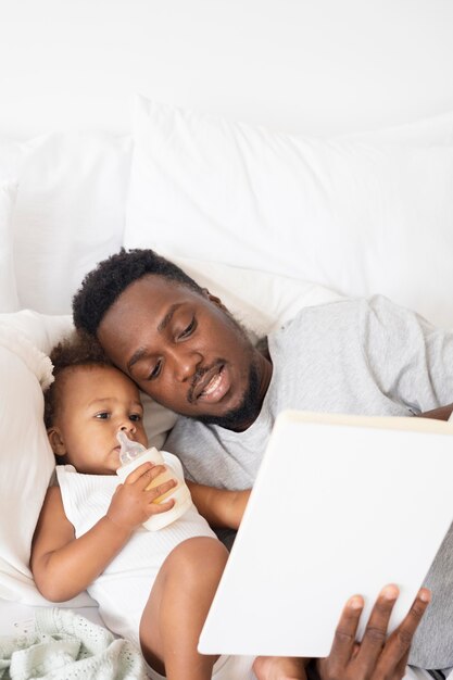 그녀의 아기 소녀에게 읽어주는 아버지