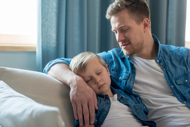 Free photo father's day child sleeping on dad's arm