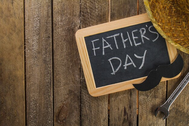 Father's day composition with slate, mustache and wrench