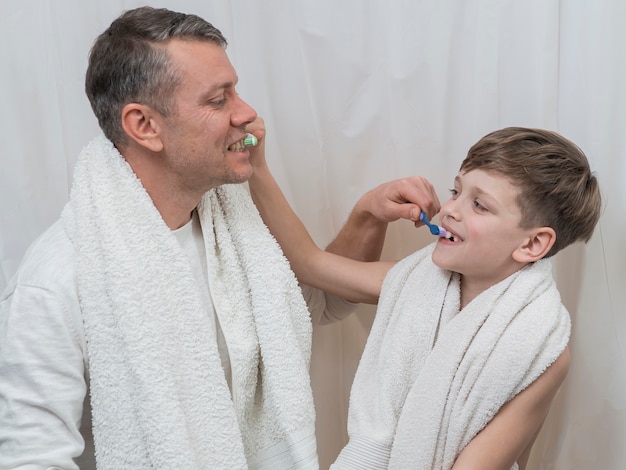 Free photo father's day dad and son brushing each other teeth