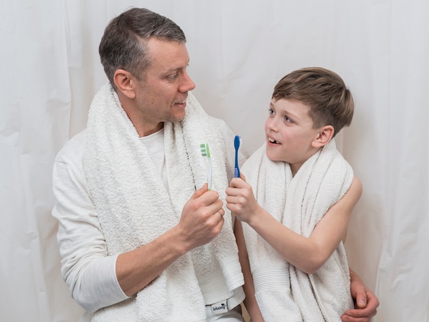 Free photo father's day dad and son holding tooth brushes