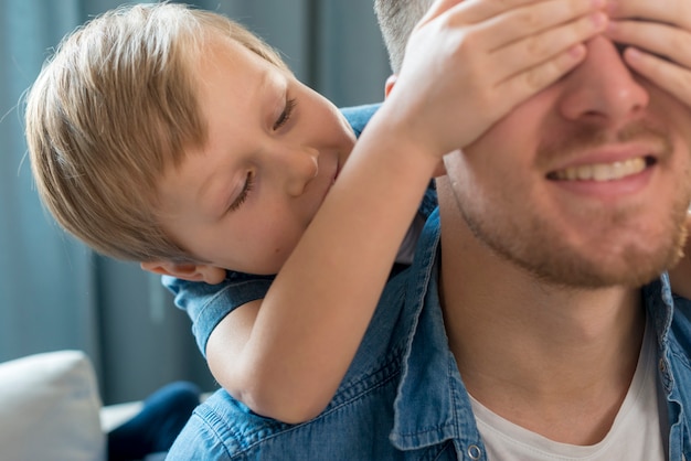 Free photo father's day son covering his dad's eyes