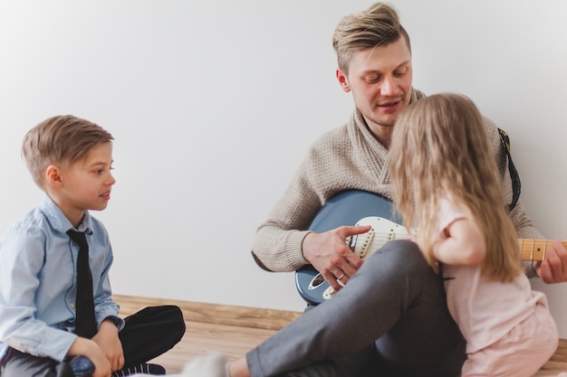 Father showing a guitar to his daughter