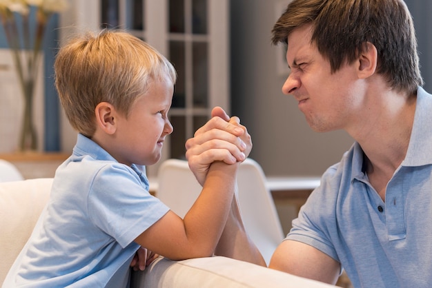 Father and son arm wrestling at home