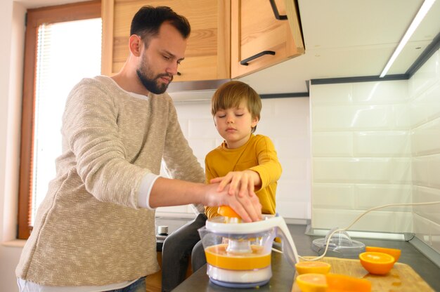 father and son being focused on making orange juice
