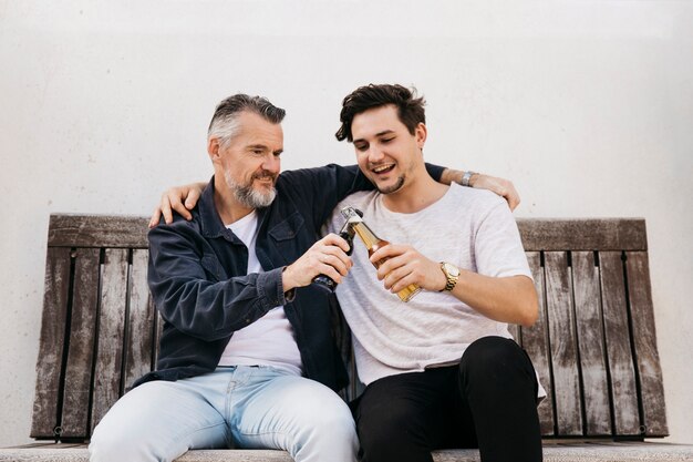 Father and son on bench with beer