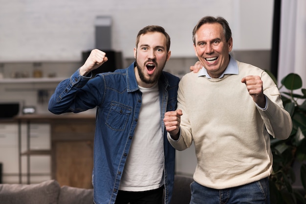Father and son cheering in living room