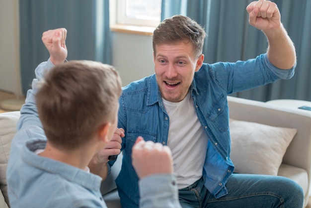 Father and son cheering in the living room