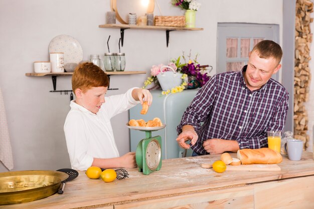 Free photo father and son cooking together