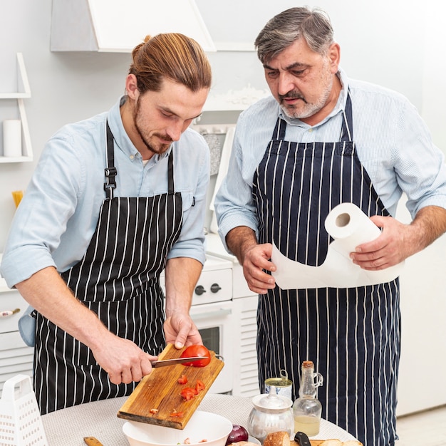 Father and son cutting tomatoes