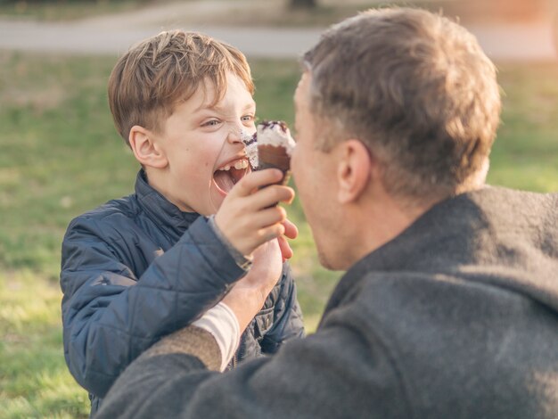 Father and son eating ice cream and fooling around