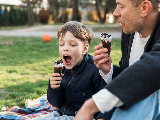 Отец и сын едят мороженое и проводят время вместе