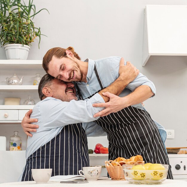 Father and son embracing in kitchen