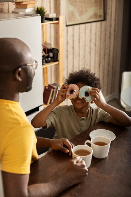 Father and son having donuts together in the kitchen