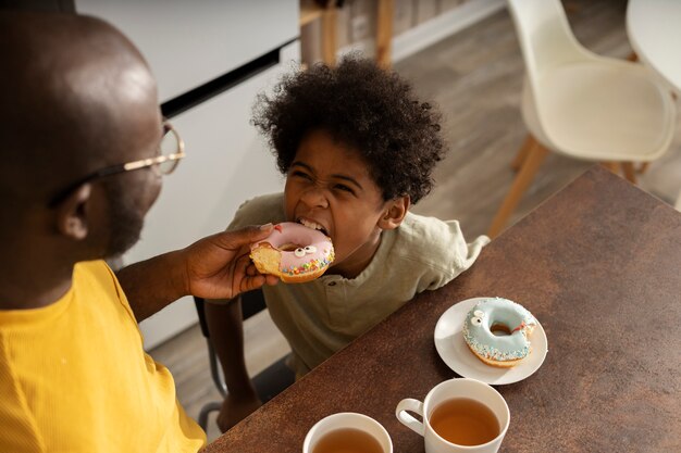 Father and son having donuts together in the kitchen
