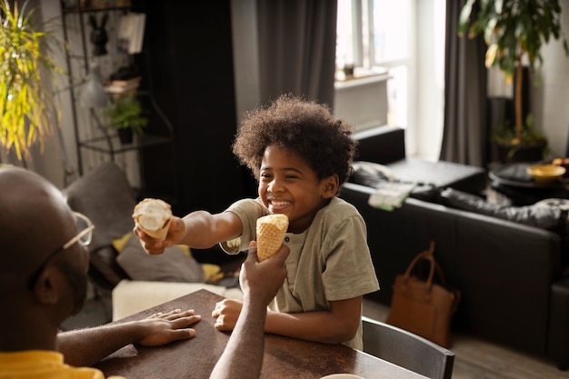 Father and son having ice cream together in the kitchen